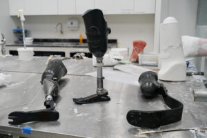 Various carbon fiber prosthetic legs displayed on a workshop table