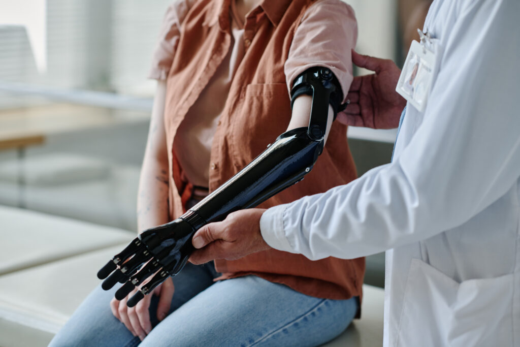 Doctor supporting and assessing a high tech prosthetic arm for a patient during evaluation