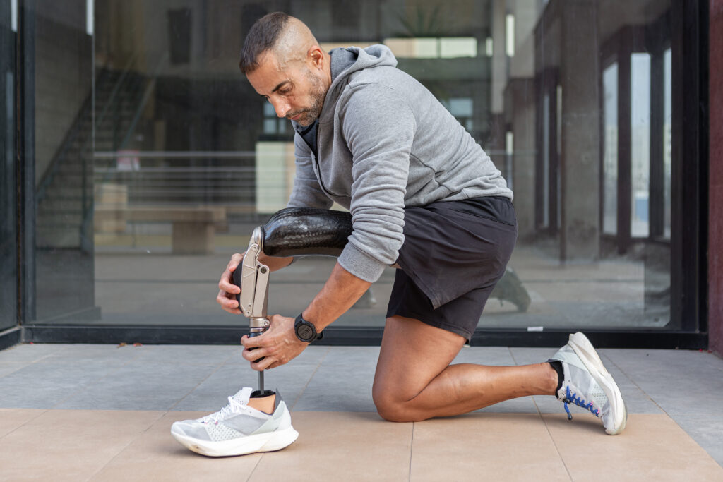Athlete adjusting prosthetics leg socket during training, highlighting performance focused prosthetic care and fit