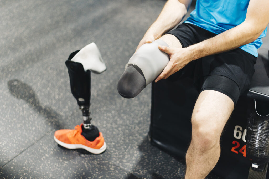 Athlete adjusting prosthetics leg socket during training, highlighting performance focused prosthetic care and fit
